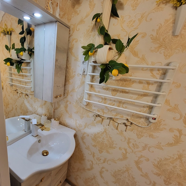 Bathroom with floor heating, sink and heated towel rack at Jázmin Apartment Debrecen.